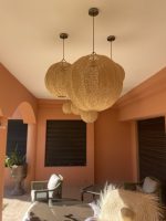 Handmade Moroccan raffia globe pendant light with elongated oval woven shape