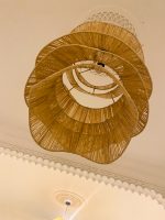 Spiral raffia pendant light with cascading handwoven layers