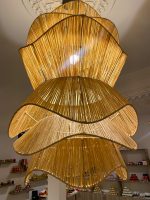 Spiral raffia pendant light with cascading handwoven layers