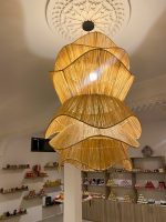 Spiral raffia pendant light with cascading handwoven layers