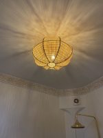Sculptural petal raffia ceiling light with handwoven natural fibers, metal frame and organic flower-shaped flush mount design.
