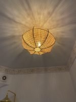 Sculptural petal raffia ceiling light with handwoven natural fibers, metal frame and organic flower-shaped flush mount design.