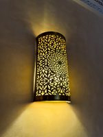 Handmade Moroccan brass wall sconce crafted from solid brass with intricate pierced detailing and warm up-and-down decorative illumination.