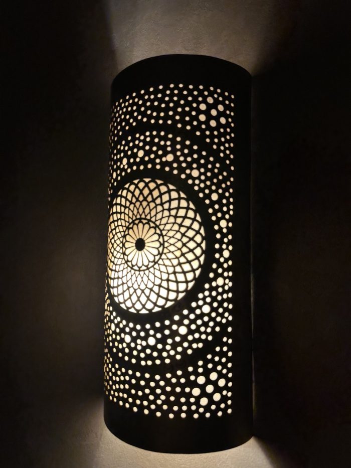 Handmade radiant rosette brass wall sconce with central geometric floral medallion and pierced decorative pattern.