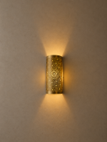 Handmade sunburst brass wall sconce with circular pierced medallion and warm up and down ambient lighting.