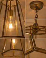 Handmade trapezoid glass pendant light with clear panels and geometric metal frame hanging from ceiling.