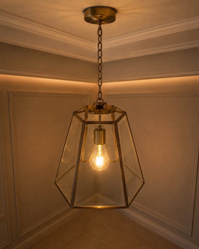 Handmade trapezoid glass pendant light with clear panels and geometric metal frame hanging from ceiling.
