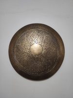 Handmade round brass wall light with floral rosette openwork, solid center medallion and warm glowing halo.
