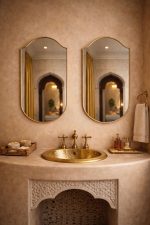 Handmade curved crown brass wall mirror with softly arched top and solid brass frame above bathroom vanity.