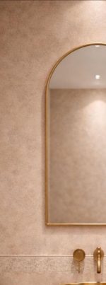 Handmade arched brass wall mirror with slim gold brass frame displayed above a bathroom vanity.