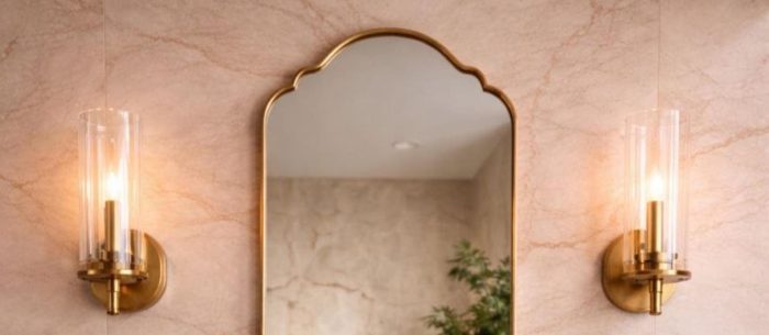 Scalloped Arch Brass Mirror above brass vessel sink and green tiled bathroom wall