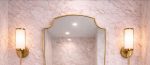 Curved Shield Brass Mirror displayed above entryway console with slim brass frame