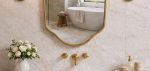 Handmade Curved Shield Brass Mirror with brass frame above wooden bathroom vanity