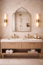 Handmade pointed arch brass wall mirror with curved shoulders and slim solid brass frame above a double bathroom vanity.