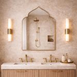 Handmade pointed arch brass wall mirror with curved shoulders and slim solid brass frame above a double bathroom vanity.