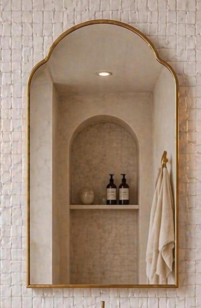 Handmade Arched Brass Vanity Mirror styled with brass sconces and bathroom vanity