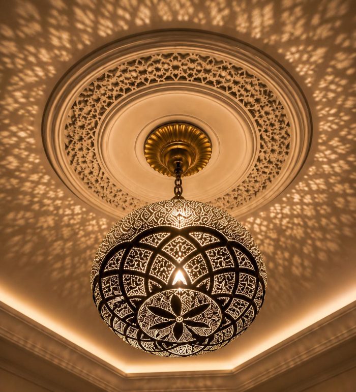 Globe Moroccan Brass Pendant Light casting decorative patterned shadows across ceiling