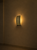 Handmade lattice filigree brass wall sconce with bowed rectangular shape, ornamental openwork and warm ambient lighting.