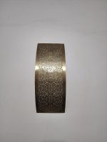 Handmade lattice filigree brass wall sconce with bowed rectangular shape, ornamental openwork and warm ambient lighting.
