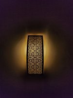 Handmade lattice filigree brass wall sconce with bowed rectangular shape, ornamental openwork and warm ambient lighting.