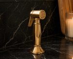 Unlacquered brass bridge faucet with cold water tap and side sprayer in farmhouse kitchen