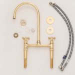 Antique brass bridge faucet with high arc gooseneck spout, cross handles and side sprayer